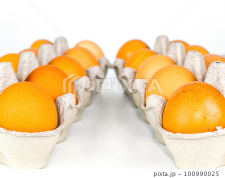 Chicken eggs in cardboard packaging on a white background. Chicken eggs in cardboard packaging on a white background. 100990025