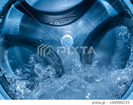 Rotating drum in the washing machine tub with water. 100990235