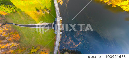 Fojtka water reservoir surrounded by vibrant colored forest at autumn time. Aerial view from drone. 100991673