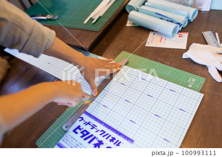 パネルばりの作品を作る女性の手 100993111