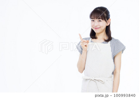 指差しをするエプロン姿の30代主婦 指差しをするエプロン姿の30代主婦 100993840