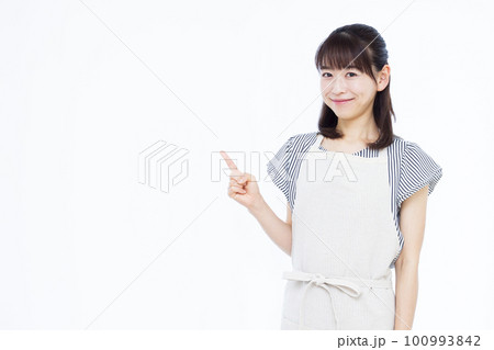 指差しをするエプロン姿の30代主婦 100993842