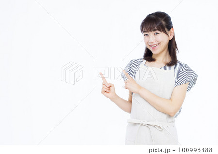 指を指すエプロン姿の30代の主婦 指を指すエプロン姿の30代の主婦 100993888