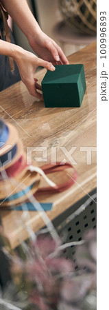 Professional florist young woman is doing bouquets at flower shop 100996893