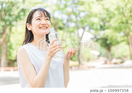 水・経口補水液で水分補給する女性 水・経口補水液で水分補給する女性 100997356