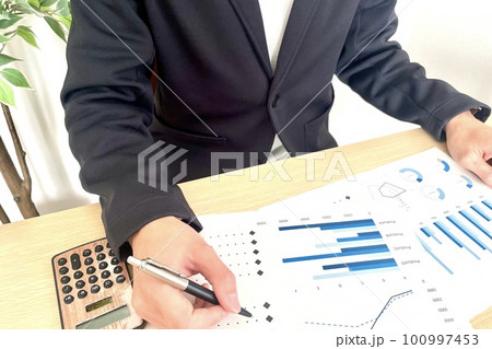 デスクで資料のチェックをする男性 100997453