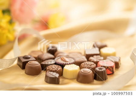 ゴールドの布の上にある甘くて美味しいお菓子のチョコレート ゴールドの布の上にある甘くて美味しいお菓子のチョコレート 100997503