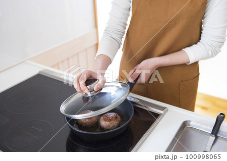 ハンバーグを焼く女性 100998065