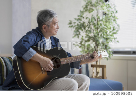 ギターを弾く60代の男性 100998605