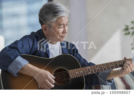 ギターを弾くシニア男性 100998607