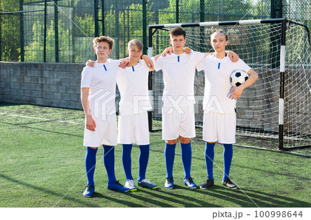 Young football team standing on pitch Young football team standing on pitch 100998644