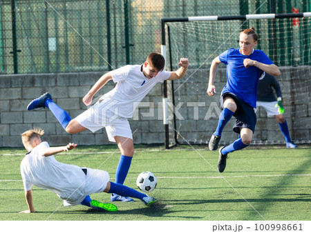 Youthful football players challenging for ball Youthful football players challenging for ball 100998661