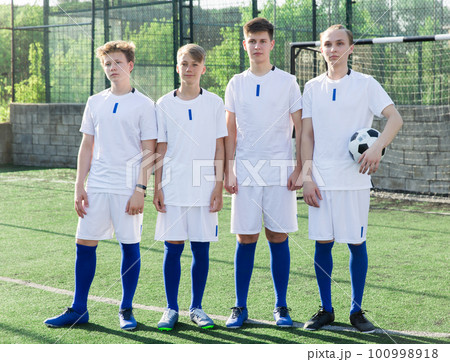 Young football team standing on pitch 100998918