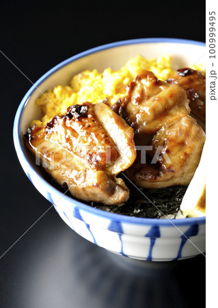 そぼろ玉子と焼き葱と刻み海苔も一緒に乗ってる照り焼きチキン丼を黒背景で撮影 そぼろ玉子と焼き葱と刻み海苔も一緒に乗ってる照り焼きチキン丼を黒背景で撮影 100999495