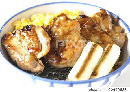 そぼろ玉子と焼き葱と刻み海苔も一緒に乗ってる照り焼きチキン丼を白背景で撮影 100999683