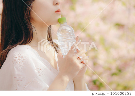 桜の木の下でペットボトルを持っている女性 桜の木の下でペットボトルを持っている女性 101000255