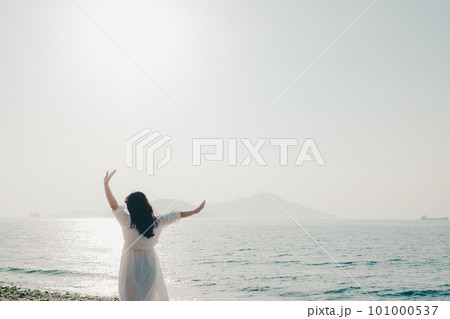 海に向かって手を伸ばす女性 101000537