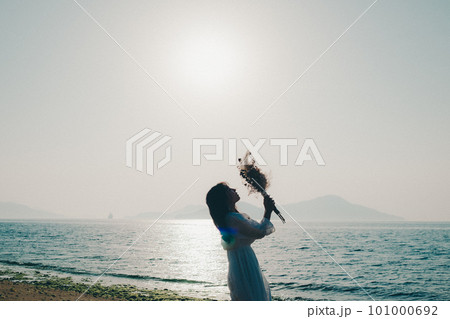 ドライフラワーを持って海を見つめる女性 101000692