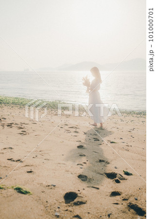 ドライフラワーを持って海を見つめる女性 101000701