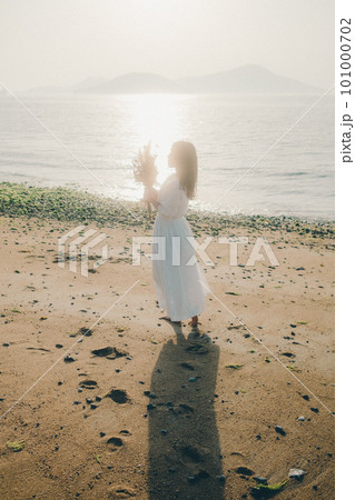 ドライフラワーを持って海を見つめる女性 ドライフラワーを持って海を見つめる女性 101000702