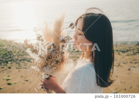 ドライフラワーを持って海を見つめる女性 101000726