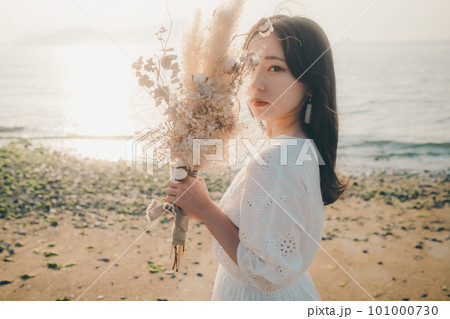 ドライフラワーを持って海を見つめる女性 ドライフラワーを持って海を見つめる女性 101000730