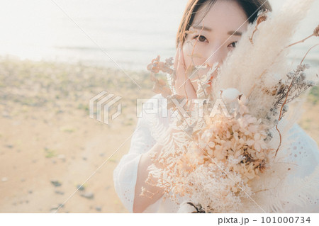 ドライフラワーを持って海を見つめる女性 101000734