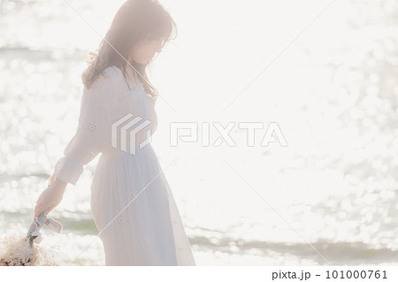 ドライフラワーを持って海を見つめる女性 101000761