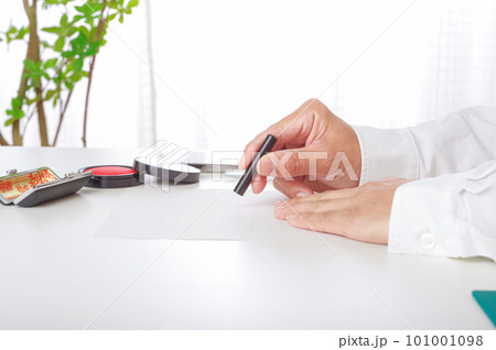 書類に判子を押す男性の手元 101001098