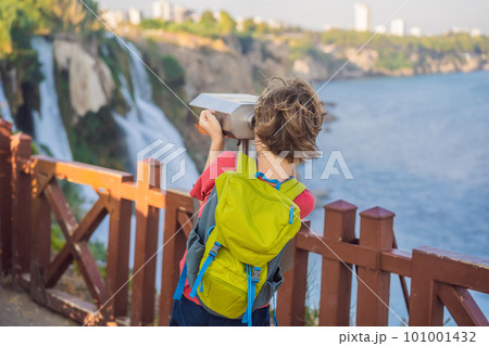 Boy tourist with a backpack on the background of Duden waterfall in Antalya. Famous places of Turkey. Lower Duden Falls drop off a rocky cliff falling from about 40 m into the Mediterranean Sea in 101001432