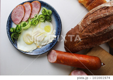 breakfast sausage ham egg scrambled eggs salad cucumber on a plate view from above on a white background. breakfast at the hotel Healthy food 101001974
