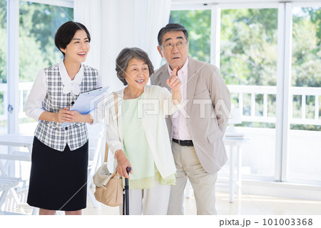シニア夫婦に説明をする女性 シニア夫婦に説明をする女性 101003368