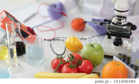 Scientist chemist studying amount of toxic substances in vegetables and fruits in chemical laboratory Scientist chemist studying amount of toxic substances in vegetables and fruits in chemical laboratory 101006480