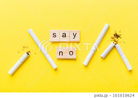 Cigarette And Wooden Blocks, Broken cigarette on table background, No Tobacco Day with hourglass, clock health concept. time to quit smoking Cigarette And Wooden Blocks, Broken cigarette on table background, No Tobacco Day with hourglass, clock health concept. time to quit smoking 101010624