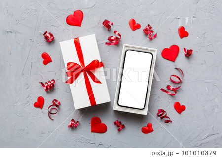 Opened gift box with ribbon and phone on color background, top view. Blank open box packaging mockup , Template for your design - branding mockup 101010879