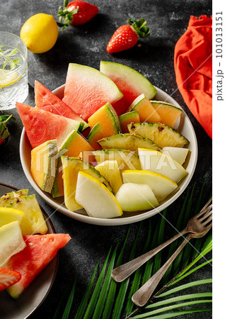 Fruits assortment platter antipasti, watermelon, pineapple, melon and strawberries. Dark background Fruits assortment platter antipasti, watermelon, pineapple, melon and strawberries. Dark background 101013151