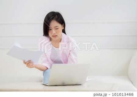 Young asian business woman working on laptop computer and looking graph and chart of report. Young asian business woman working on laptop computer and looking graph and chart of report. 101013466