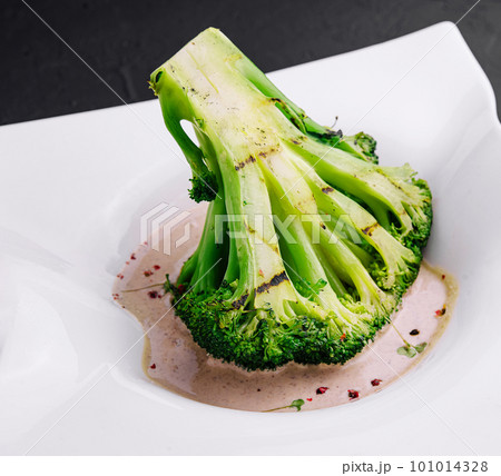 Broccoli steak with walnut sauce on plate Broccoli steak with walnut sauce on plate 101014328