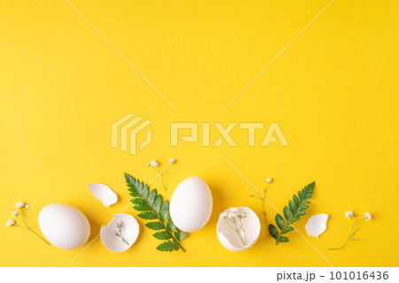 White Easter eggs and shells on a bright yellow background. 101016436