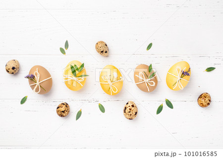 Easter eggs with flowers on a white table. Easter eggs with flowers on a white table. 101016585