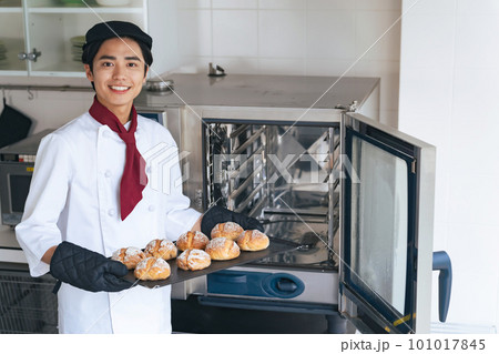 オーブンからパンを取り出すパン職人 101017845