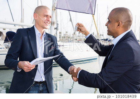 men with documents and keys near the yachts in the port 101018439