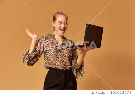 Portrait of remote young teacher woman talking and looking at webcam with excited face over orange background. Teaching students, doing video chat 101018578