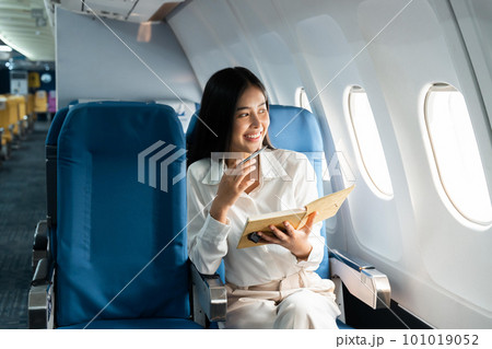 Asian female thinking about work in airplane concept Business traveling and technology concept Asian female thinking about work in airplane concept Business traveling and technology concept 101019052