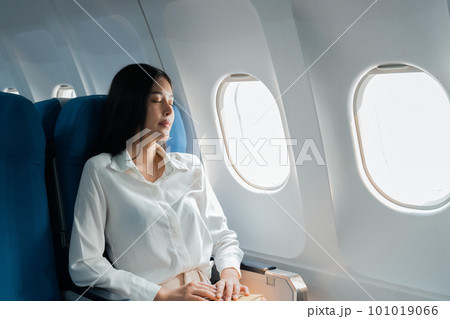 A female passenger traveling by plane sleeping on cushion airplane 101019066