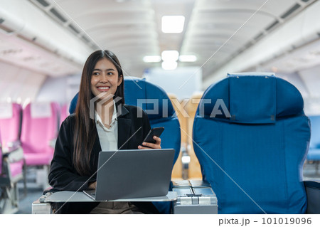 transport, tourism and technology concept of business woman with smartphone and laptop traveling by plane 101019096