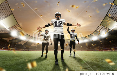 Winning championship. Male athletes, professional american football players in uniform after winning game at open air 3D stadium with confetti Winning championship. Male athletes, professional american football players in uniform after winning game at open air 3D stadium with confetti 101019416