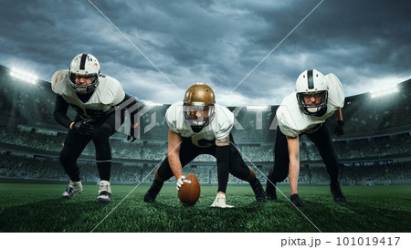 Three sportsmen, american football players in uniform getting ready to play at open air at 3D stadium in evening time. Championship Three sportsmen, american football players in uniform getting ready to play at open air at 3D stadium in evening time. Championship 101019417