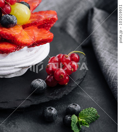 Mini pavlova meringue cake decorated with fresh berries 101019931