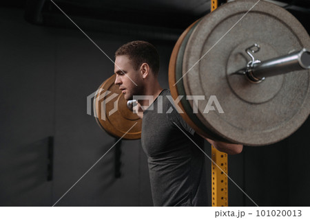Crossfit athlete doing weight lift squats with barbell 101020013